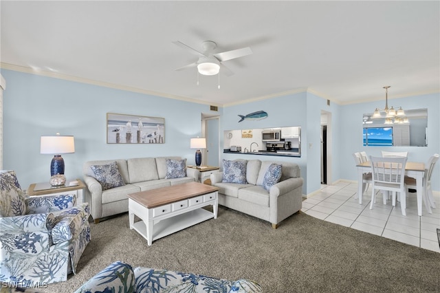 living room featuring light tile patterned floors, ceiling fan with notable chandelier, and crown molding