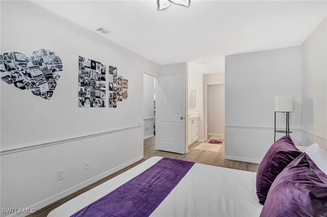 bedroom featuring connected bathroom and light wood-type flooring