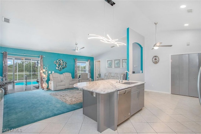 kitchen with a center island with sink, stainless steel dishwasher, hanging light fixtures, and a wealth of natural light