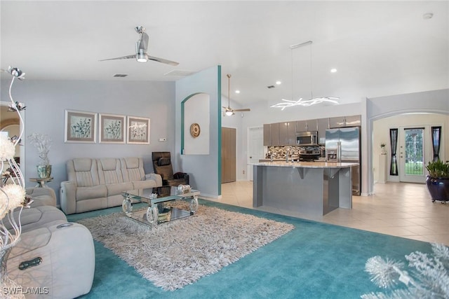 tiled living room featuring vaulted ceiling and ceiling fan