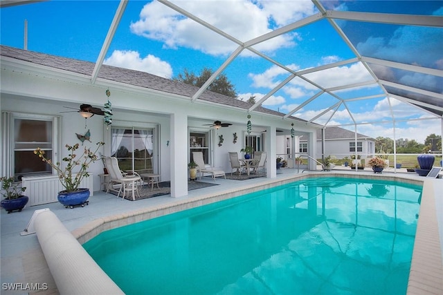 view of swimming pool featuring ceiling fan, a patio area, and a lanai