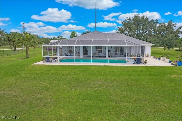 rear view of house featuring a yard, a patio area, and a lanai