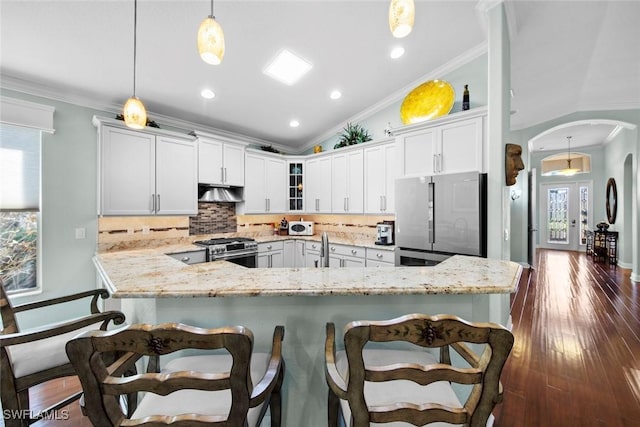 kitchen featuring tasteful backsplash, white cabinetry, pendant lighting, and stainless steel appliances