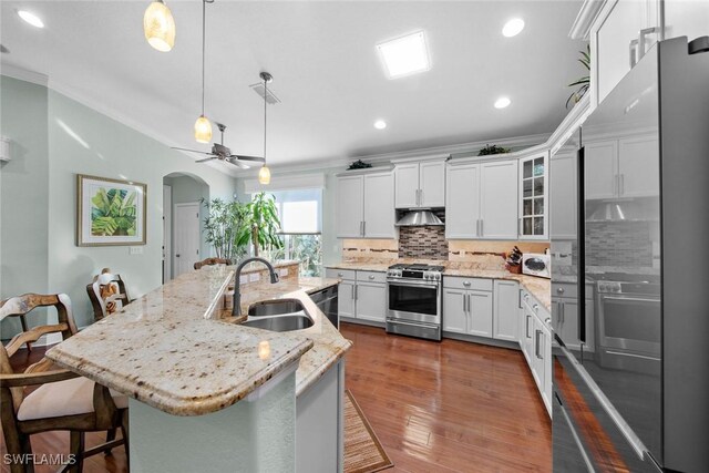 kitchen with sink, decorative light fixtures, a breakfast bar area, a kitchen island with sink, and appliances with stainless steel finishes