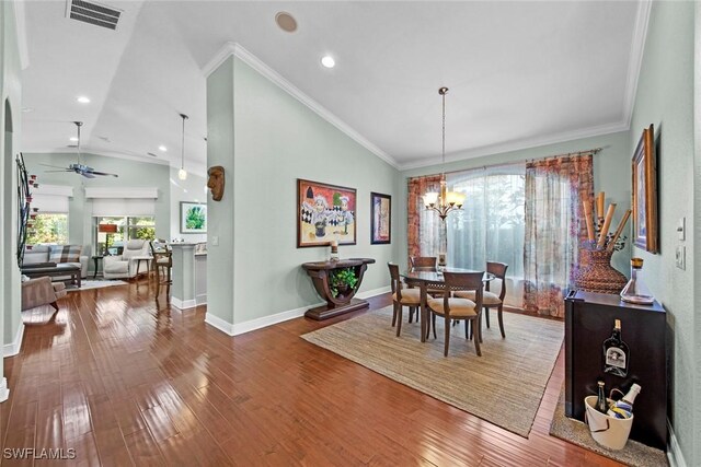 dining space featuring ceiling fan with notable chandelier, a healthy amount of sunlight, lofted ceiling, and crown molding