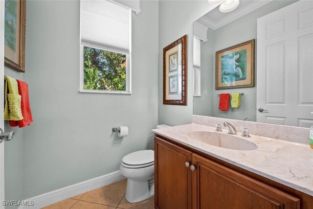 bathroom featuring tile patterned floors, vanity, toilet, and crown molding