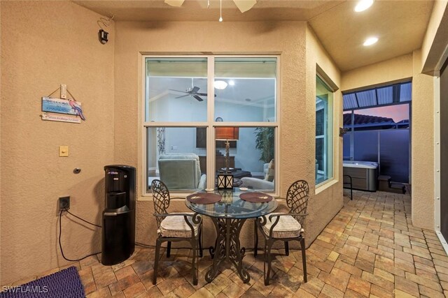 view of patio with ceiling fan and a hot tub