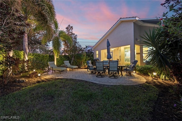 yard at dusk featuring a patio area and fence