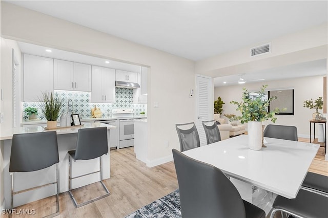 dining room with a healthy amount of sunlight and light hardwood / wood-style floors