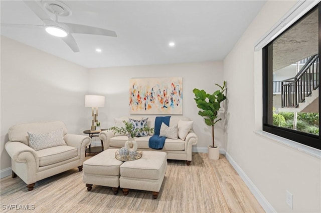 living room with light hardwood / wood-style floors and ceiling fan