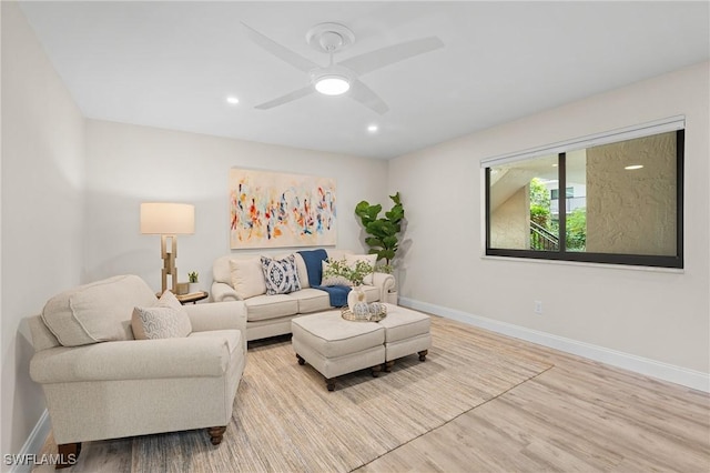 living room with light hardwood / wood-style flooring and ceiling fan