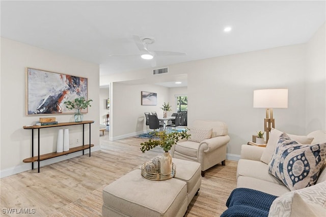 living room featuring ceiling fan and light hardwood / wood-style flooring