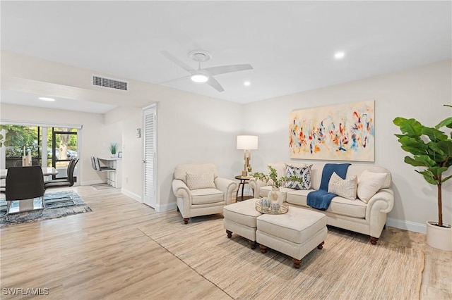 living room with light hardwood / wood-style flooring and ceiling fan