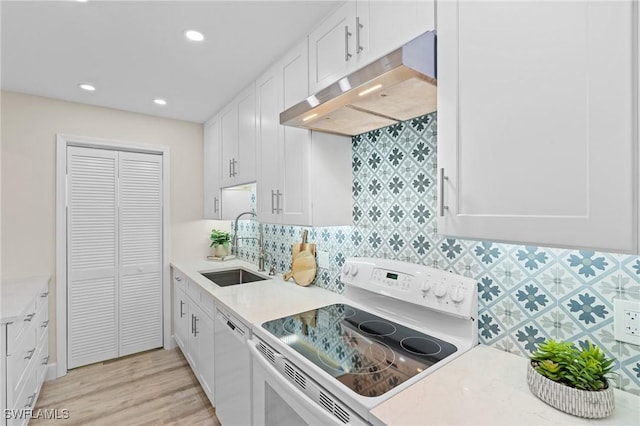 kitchen with white cabinetry, sink, stove, white dishwasher, and light wood-type flooring