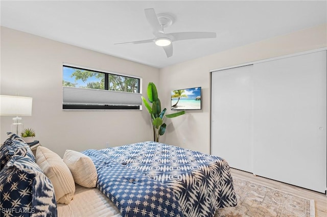 bedroom with ceiling fan, a closet, and light hardwood / wood-style flooring