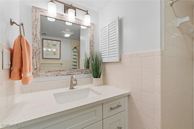 bathroom featuring vanity, tile walls, and walk in shower