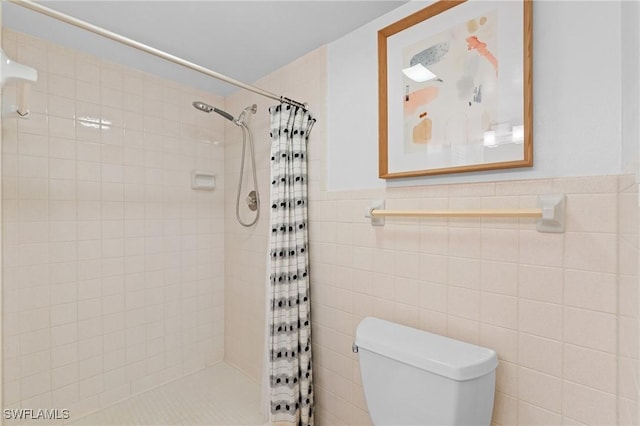 bathroom featuring toilet, tile walls, and walk in shower