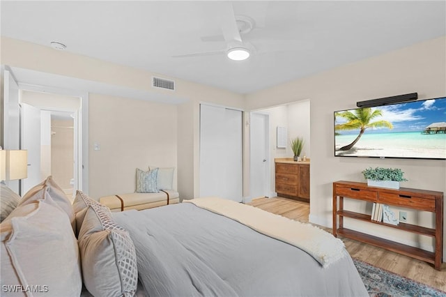 bedroom featuring ceiling fan, light wood-type flooring, and connected bathroom