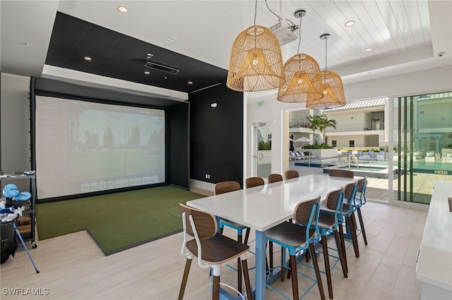 dining space featuring golf simulator, a tray ceiling, wood ceiling, and plenty of natural light