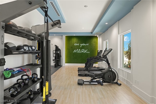 exercise room with baseboards, wood finished floors, and recessed lighting