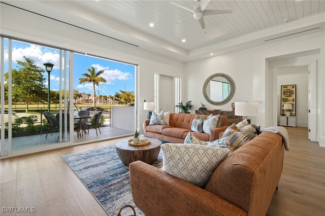 living area with ceiling fan, recessed lighting, wood ceiling, light wood finished floors, and a raised ceiling