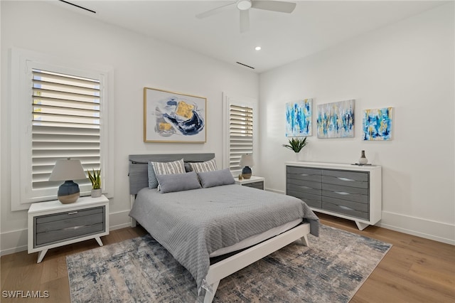 bedroom featuring ceiling fan, baseboards, wood finished floors, and recessed lighting