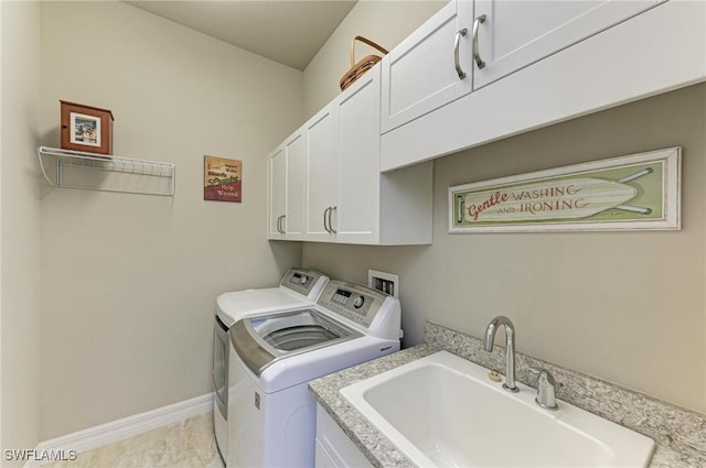 laundry room featuring cabinets, sink, and washer and clothes dryer