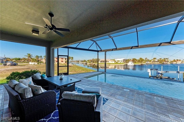 view of patio / terrace with a water view, ceiling fan, an outdoor living space, and a lanai