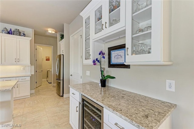 kitchen with white cabinetry, stainless steel fridge, and beverage cooler