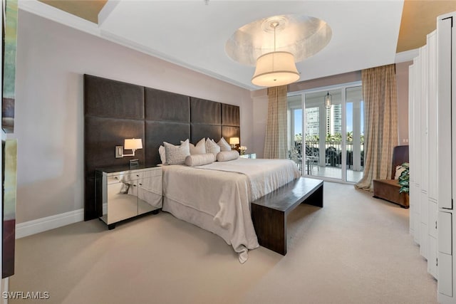 bedroom featuring access to exterior, a tray ceiling, light carpet, and baseboards