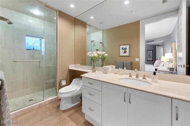 ensuite bathroom featuring toilet, a stall shower, connected bathroom, and wood finished floors