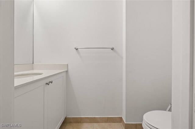 bathroom featuring tile patterned flooring, vanity, and toilet