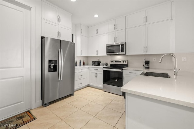 kitchen featuring sink, white cabinetry, stainless steel appliances, and light tile patterned floors