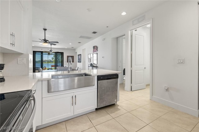 kitchen with ceiling fan, sink, kitchen peninsula, white cabinets, and appliances with stainless steel finishes