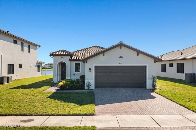 view of front of property featuring a front yard, a garage, and cooling unit