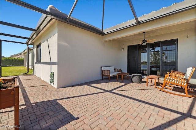 view of patio featuring glass enclosure and ceiling fan