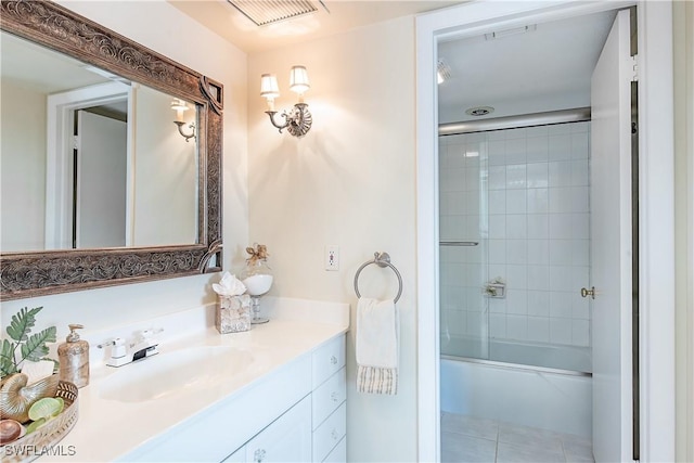 bathroom featuring tile patterned flooring, vanity, and enclosed tub / shower combo