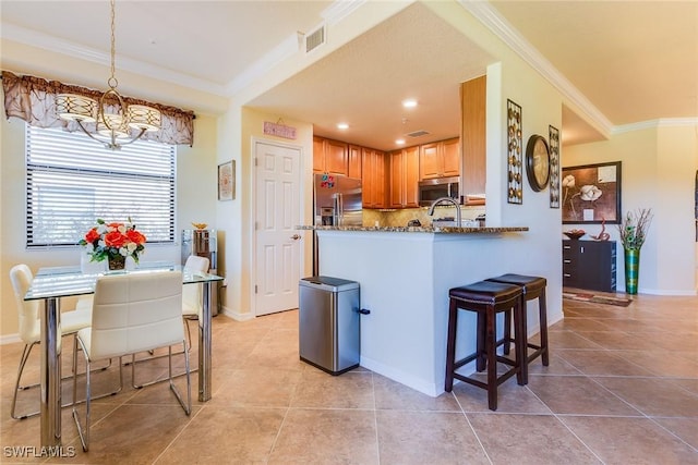 kitchen with pendant lighting, decorative backsplash, appliances with stainless steel finishes, light tile patterned flooring, and kitchen peninsula