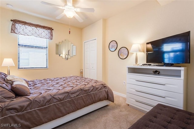 carpeted bedroom with ceiling fan and a closet