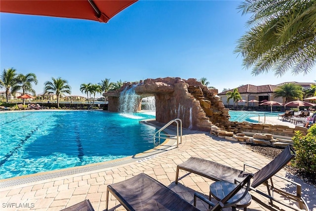 view of swimming pool featuring pool water feature and a patio area