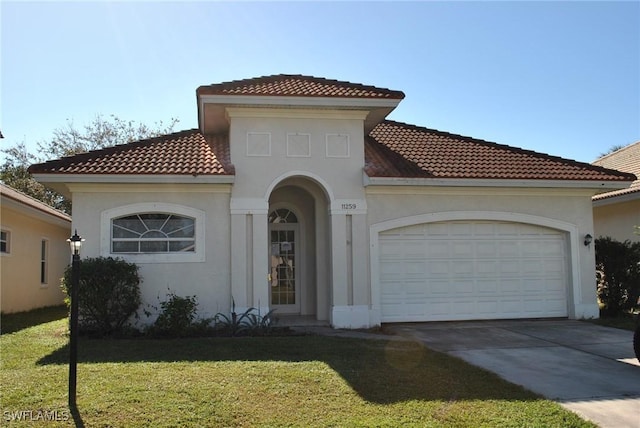 mediterranean / spanish-style home with a front yard and a garage