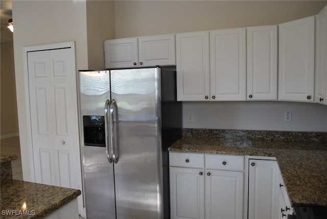 kitchen with white cabinets, ceiling fan, stainless steel refrigerator with ice dispenser, and dark stone counters