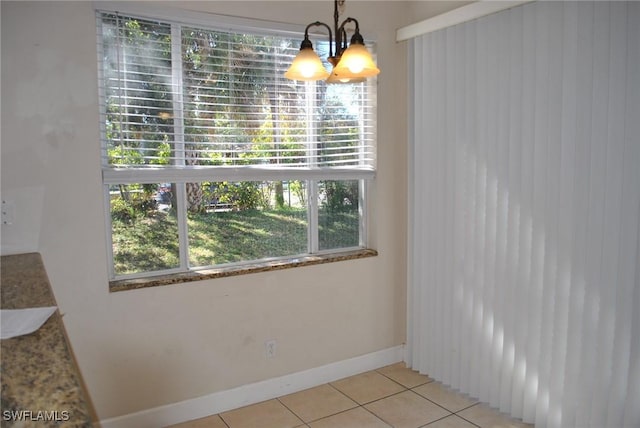 unfurnished dining area featuring light tile patterned flooring and an inviting chandelier