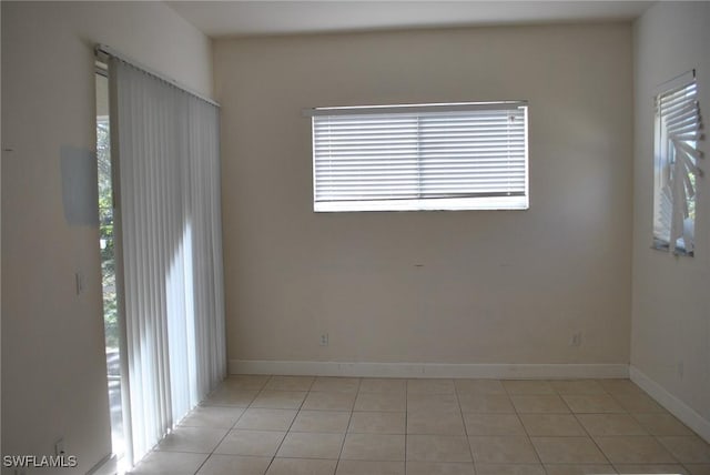 unfurnished room with light tile patterned flooring and a wealth of natural light