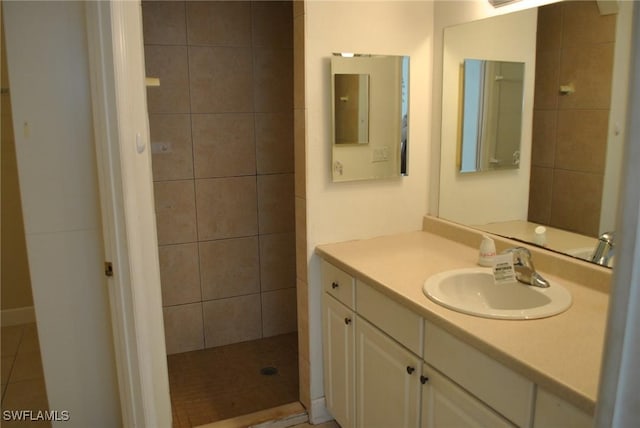 bathroom featuring a tile shower and vanity