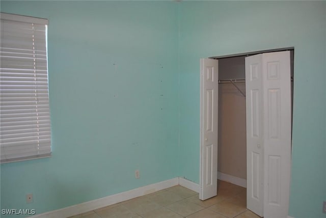 unfurnished bedroom with a closet and light tile patterned floors