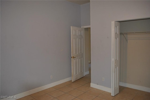 unfurnished bedroom with a closet and light tile patterned flooring