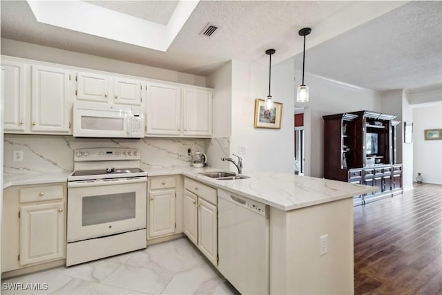 kitchen with kitchen peninsula, white appliances, tasteful backsplash, and sink