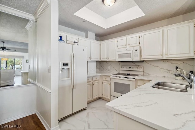 kitchen with decorative backsplash, white appliances, light stone counters, and sink