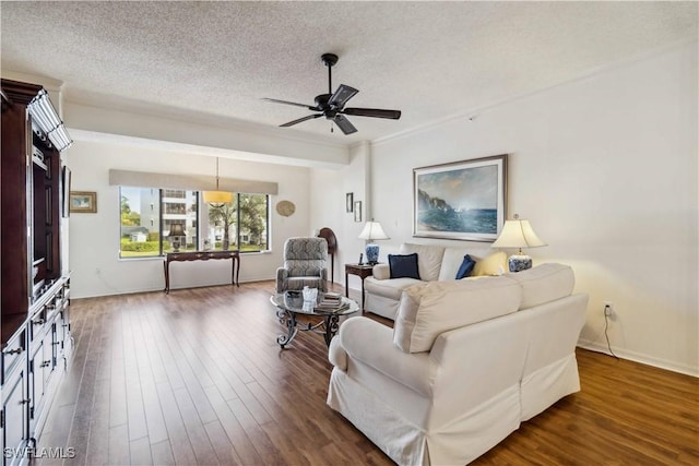 living room with ceiling fan, dark hardwood / wood-style flooring, and a textured ceiling